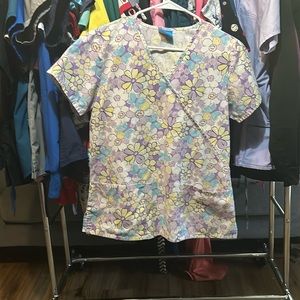 Scrub top, purple, yellow, white flowers accented by blue butterflies.